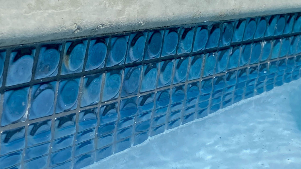 A closeup shot of the Aura Black 3d glass tile installed in a waterline.