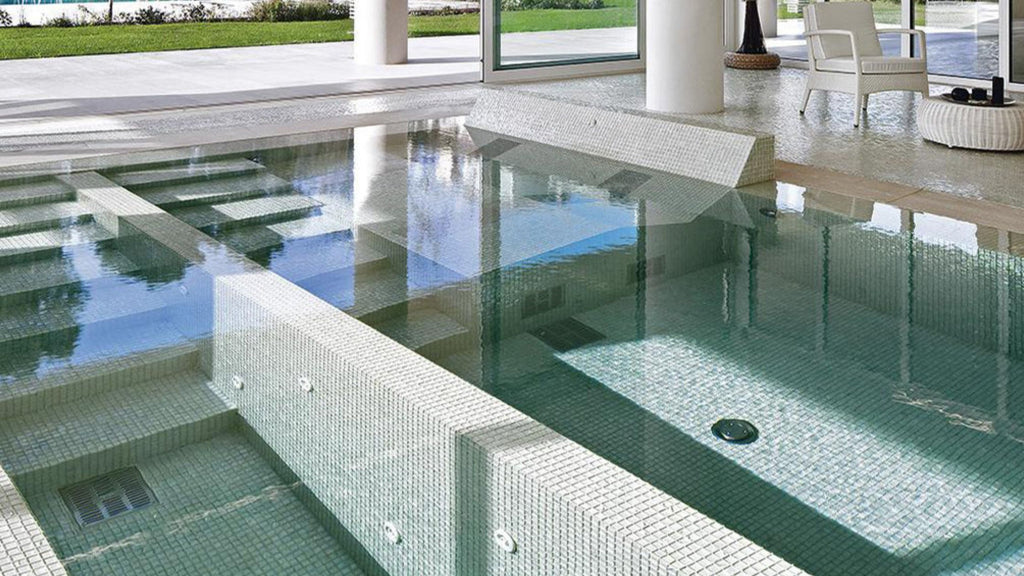 white, small-format glass tile by SICIS installed as an all-glass tile pool finish in a luxury pool.