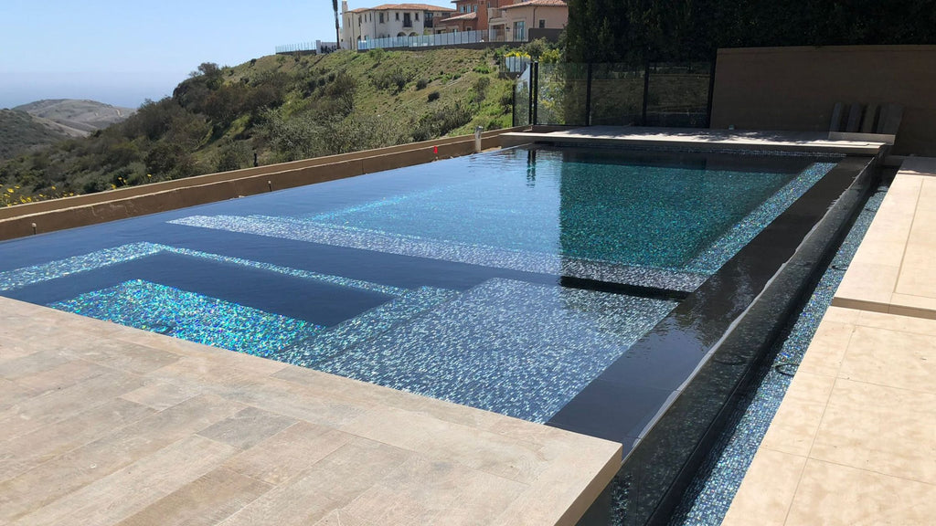 iridescent black small glass tile installed as an all-tile finish for a luxury pool over looking a beautiful, forested mountain side.