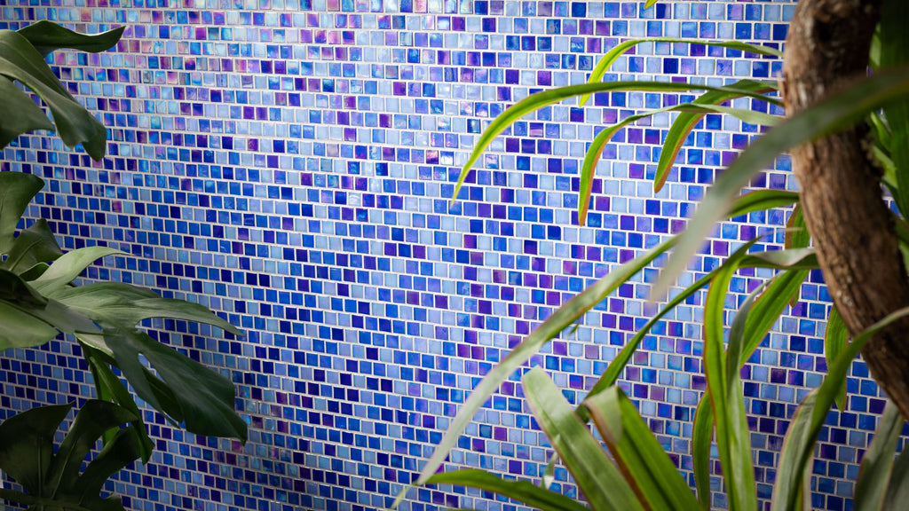 blue tile from the Aquarius collection. It's surrounded by tropical green plants.