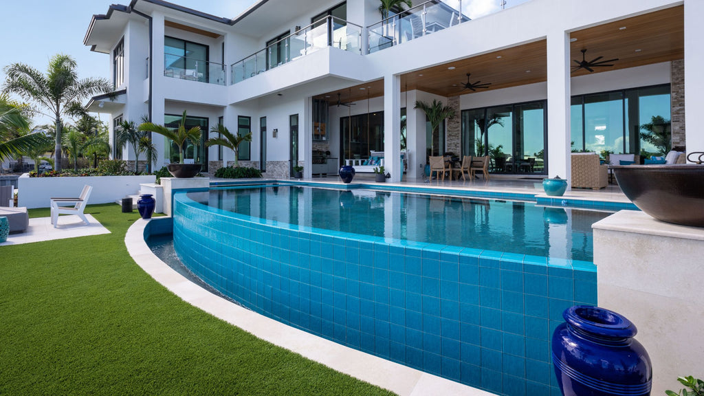 Blue 6" x 6" tile in a luxury pool behind a large, modern home.