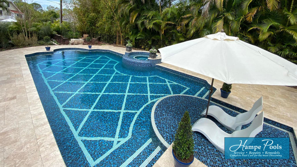 beautiful all glass tile pool by Jeff Hampe pools that was featured on designing spaces. The tiles are a mix of dark and lighter blues with a beautiful white geometric mosaic design that runs across the floor and matches the borders installed