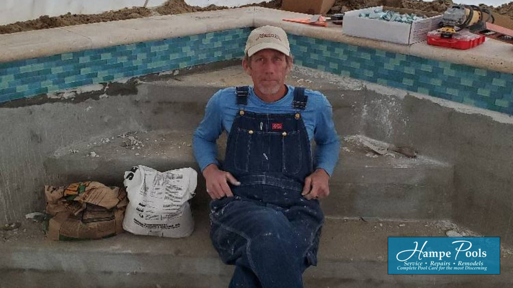 Jeff Hampe working in a pool with blue and aqua subway glass tile in the waterline.