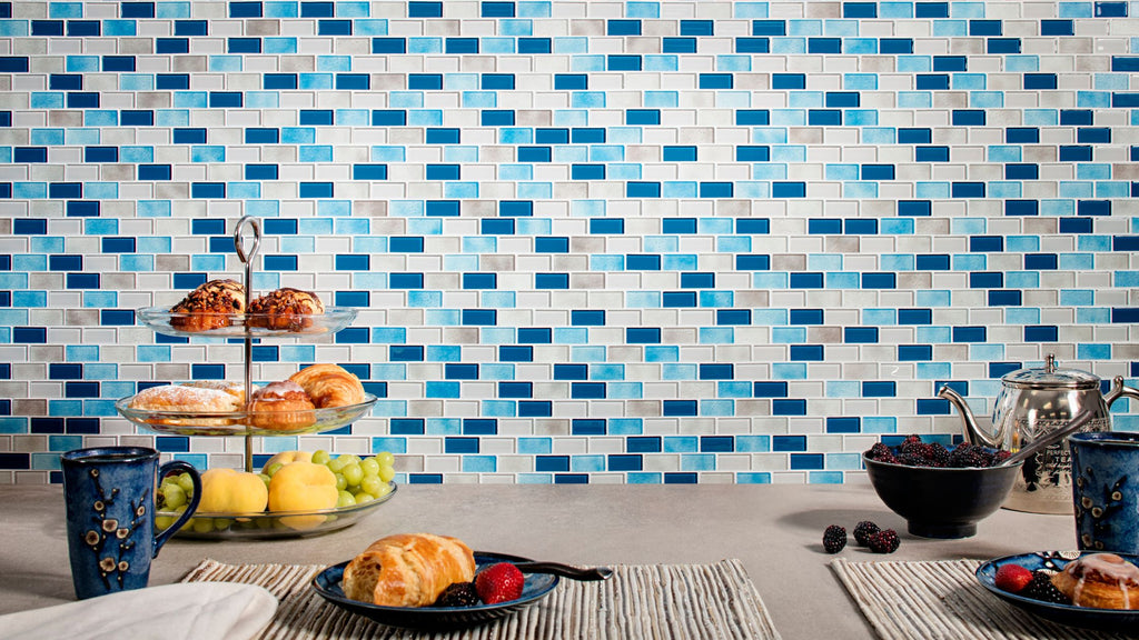 small subway tile in a mix of dark blue, light blue, and white used in a kitchen backsplash.