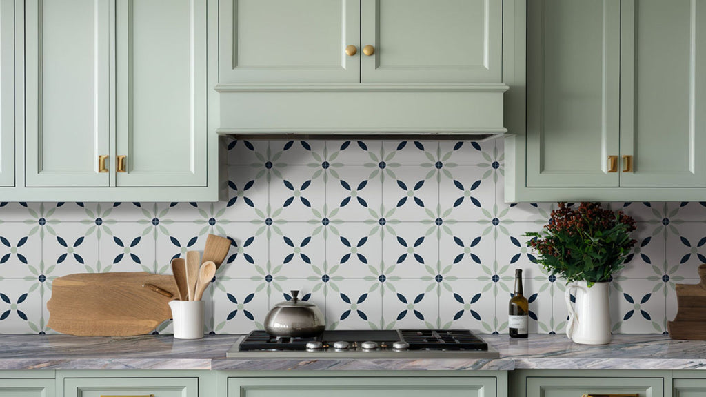Green, blue, and white patterned backsplash tile. It's a modern floral print design. The cabinets are a light green to match the green in the tile.