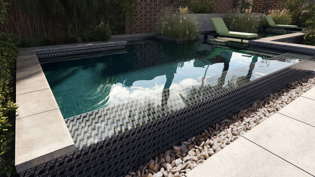 Splash format glass tile in a beautiful infinity pool. It's surrounded by lush trees and green outdoor furniture.