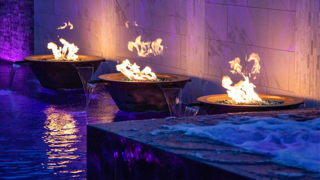 Fire and water combination bowls lined up 2 feet apart in front of an accent wall that runs water into the pool
