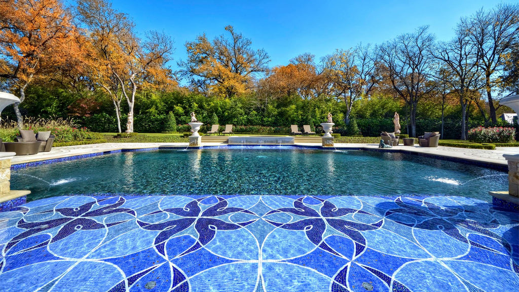 A beautiful, custom mosaic made up of small format tiles in various shades of blue used as a tile finish on a pool sun shelf.