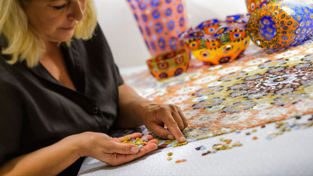 Artisan woman working on a colorful Venetian glass tile mosaic.
