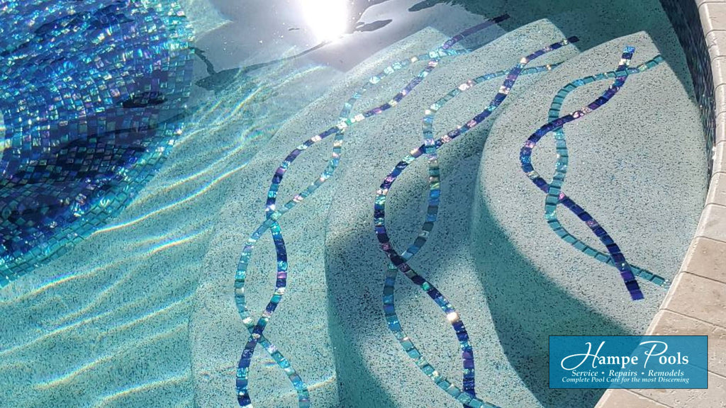 custom mosaic pool step markers with blue and aqua colored glass tiles in a beautiful helix-like pattern.