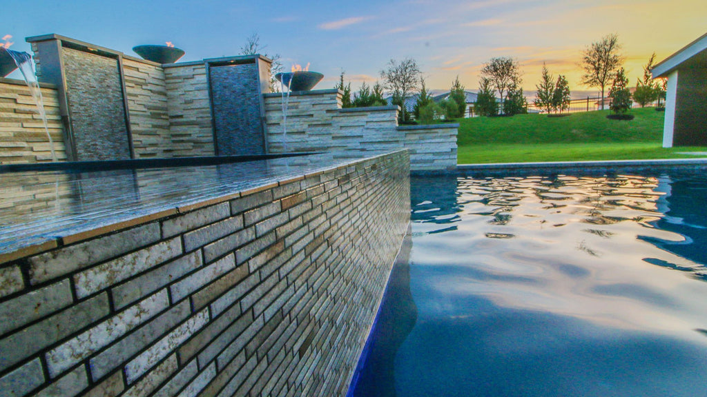 Linear porcelain pool tile installed in a waterline and an outdoor accent wall.