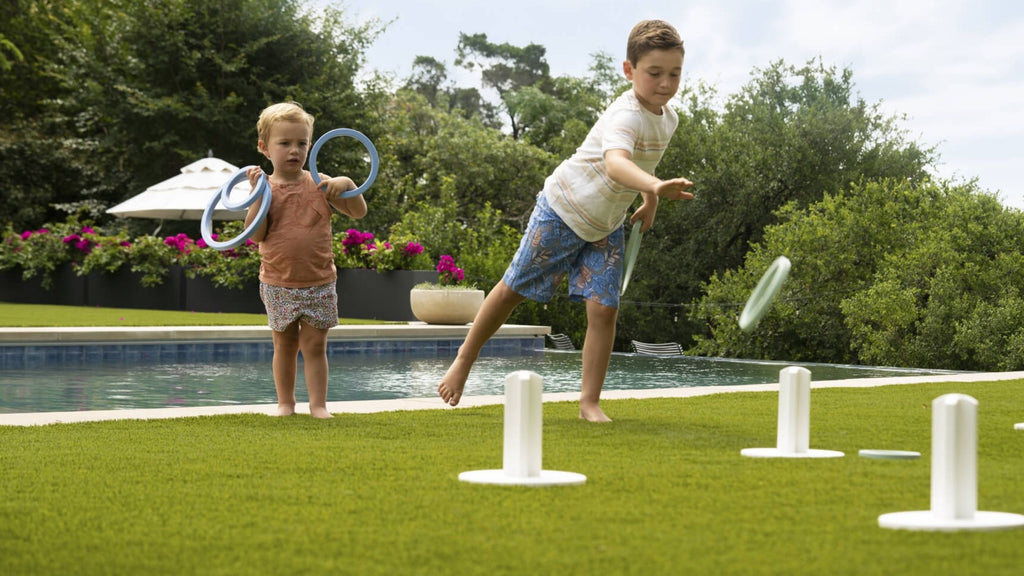 Ledge Lounger ring toss being played by young children in beautiful backyard