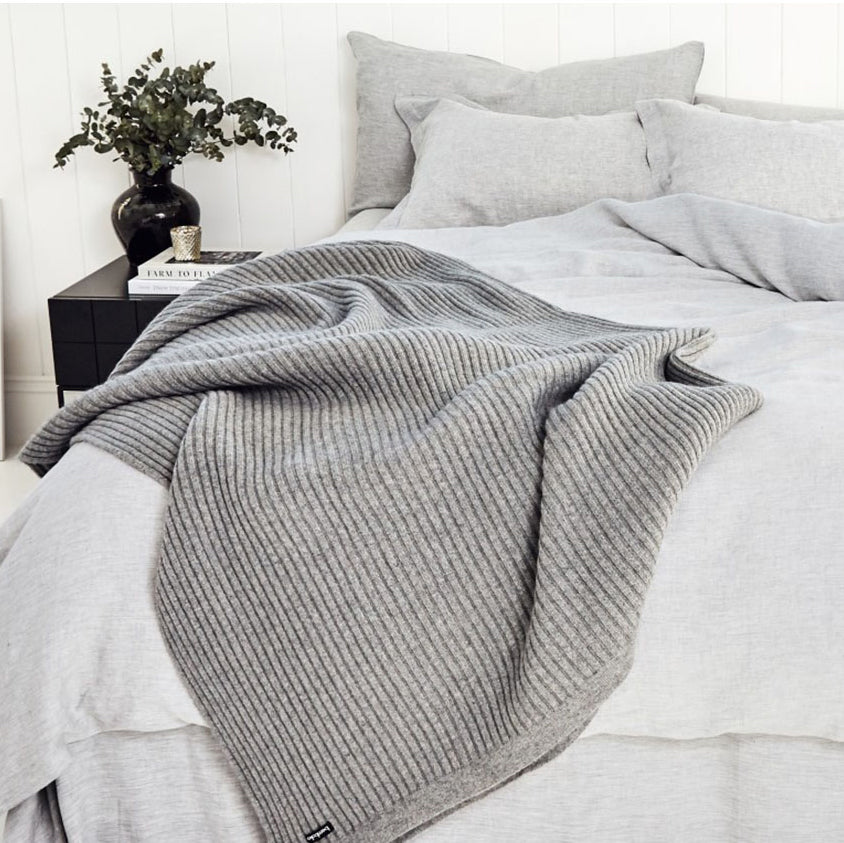 Bemboka Angora Merino Wool Wide Rib Throw on the corner of a bed.