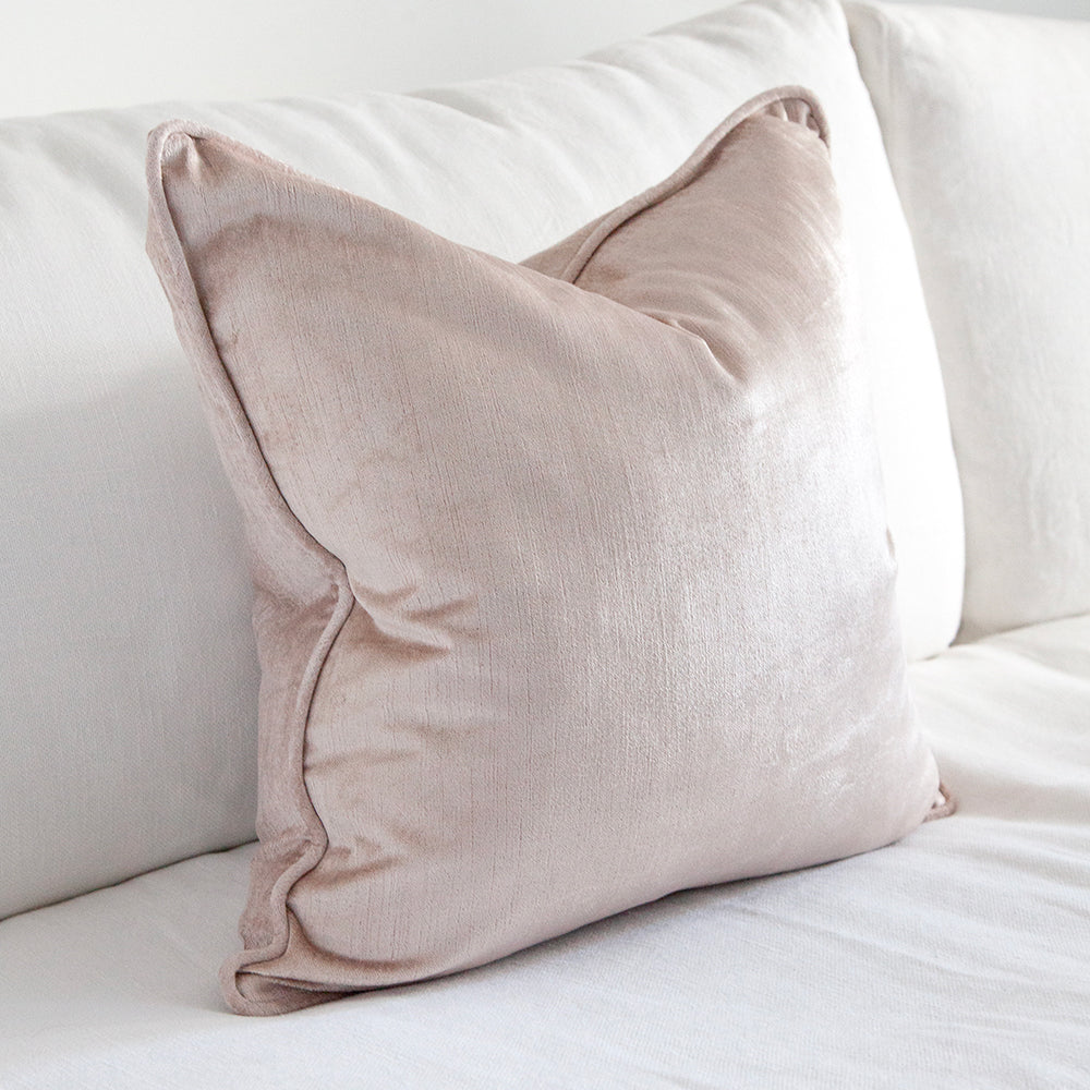 square dusty pink velvet cushion on white sofa