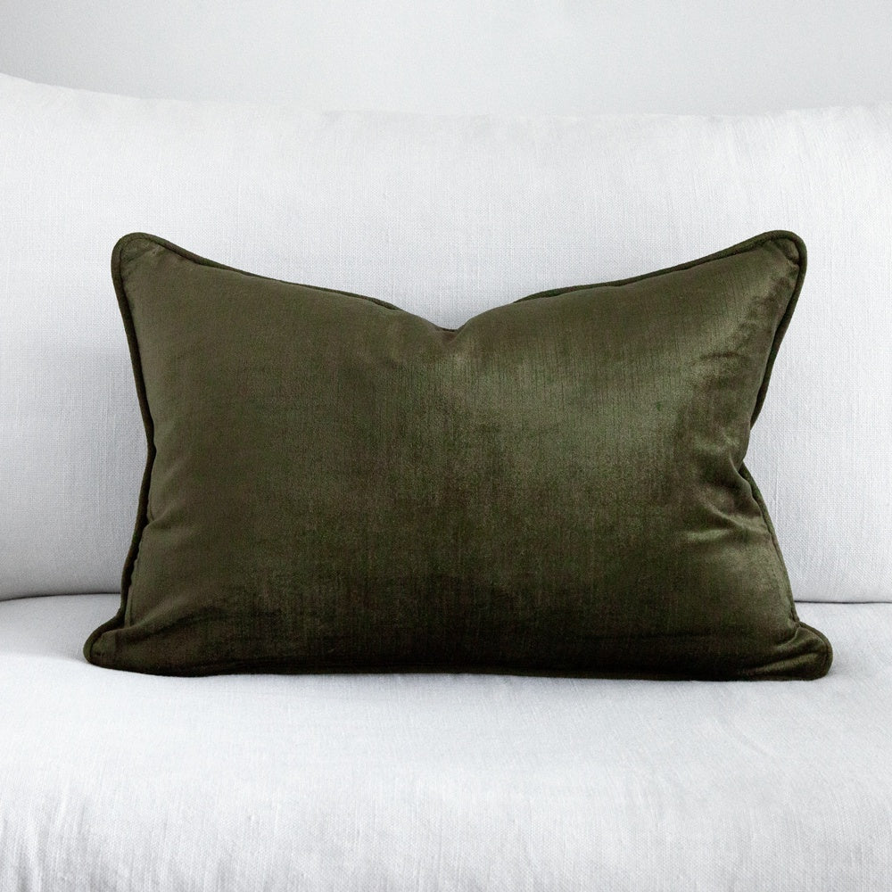 dark green velvet cushion on white sofa