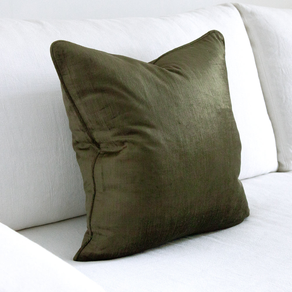square dark green velvet cushion on white sofa