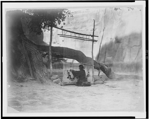 Navajo weaver at her outdoor loom in Canyon de Chelly. by E.S. Curtis, 1907
