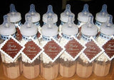 alt="hot chocolate baby shower favours, baby bottles filled with chocolate powder and marshmallows"