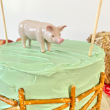 Toy pig on farm themed cake