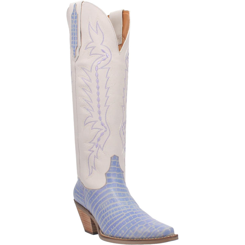 A tall periwinkle and white boot. The top half of the boot is white with a periwinkle stitched design. The bottom half is periwinkle with a reptile skin pattern. Also features a small heel, V cut top, and leather straps with a hint of the periwinkle reptile print in the middle. Item is pictured on a white background.