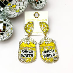 Beads, Pearls, and Crystals Yellow Can Earrings with Lemon Slice Studs. Pictured on a white background with disco balls in the top left.