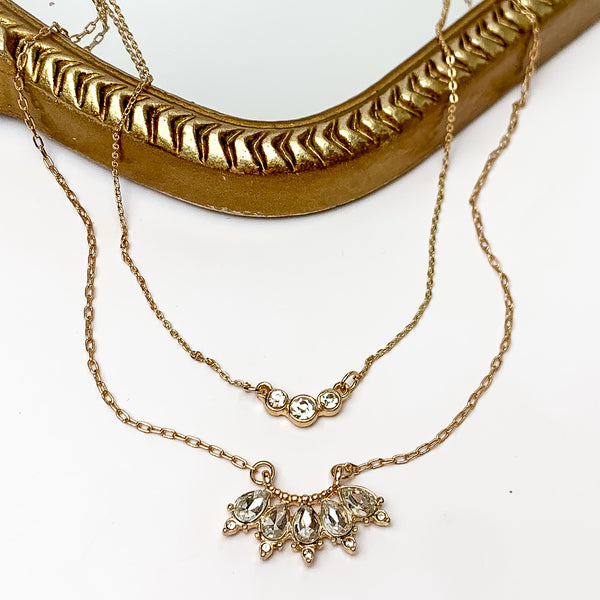 Dazzling Gold Tone Necklace With Clear Crystals. Pictured on a white background with a gold frame behind the necklace.