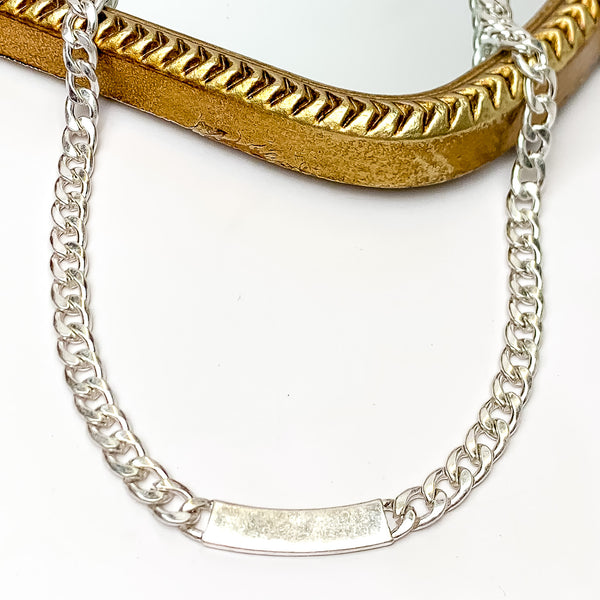Silver Tone Chain Link Necklace with Silver Plaque. Pictured on a white background with disco balls on the left side.