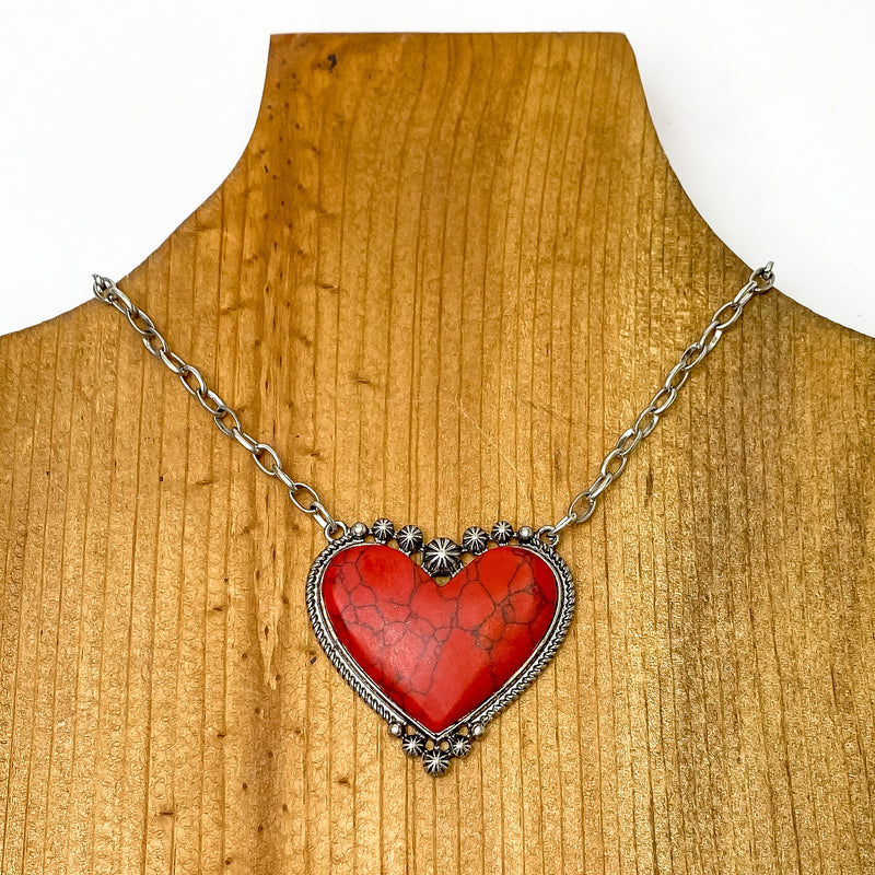 Silver Chain Necklace with Stone Heart Pendant in Red. Pictured on a brown necklace holder on a white background. 