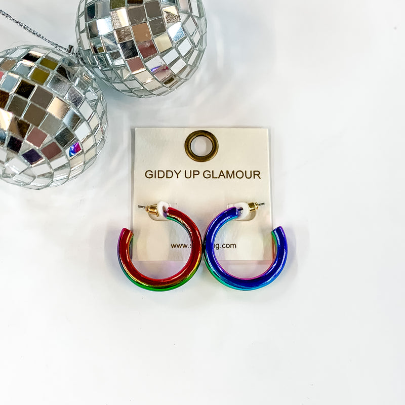 Light Up Small Neon Hoop Earrings In Multicolored. Pictured on a white background with a disco ball in the top left corner.