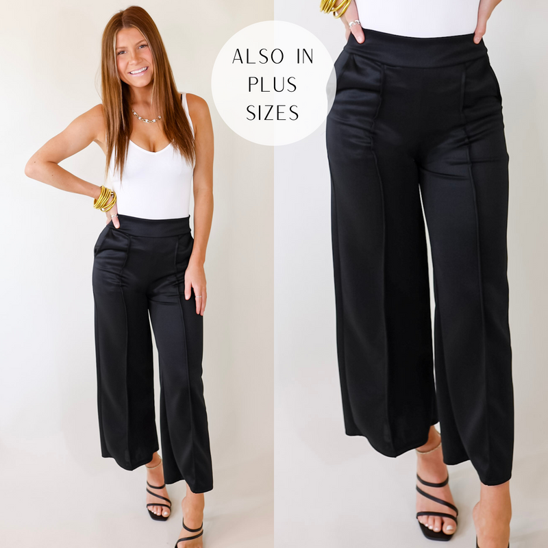 A pair of black mid rise pants with a front pleat on both legs, pockets, and a straight leg style