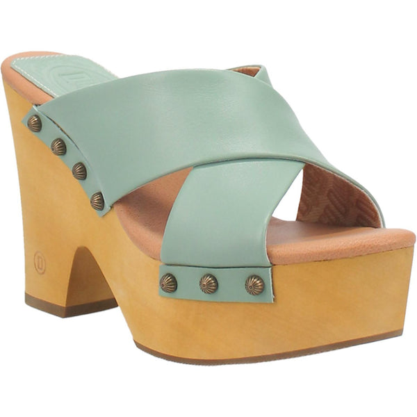 A chunky heeled sandal with two mint green crossed straps that are fastened in place with round studs. Item is pictured on a plain white background