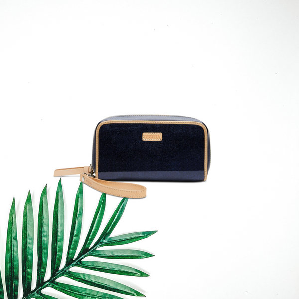 Centered in the picture is a sparkly blue wallet with a palm leaf to the right. All on a white background. 