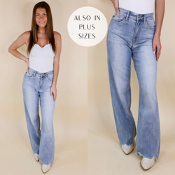 Model is wearing a pair of light wash straight leg jeans. Model has it paired with a white tank top, ivory booties, and gold jewelry.