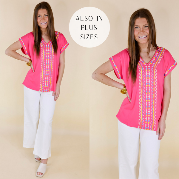 Model is wearing a hot pink short sleeve top with embroidery down the front. Model has it paired with white jeans, white heels, and gold jewelry.