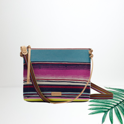 Centered in the middle of the picture is a medium sized purse in a purple/blue mix. To the right of the purse is a palm left on a white background. 