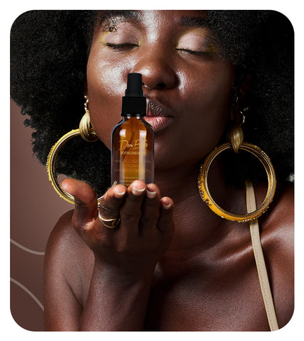 Woman with bottle of Brown Cosmetics Hair Oil in hand