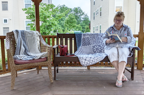 grandma reading book on bench