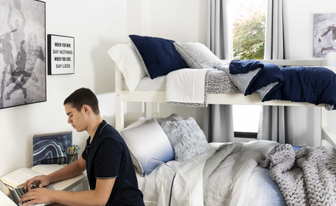 Guy studying in dorm room 