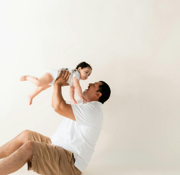 dad playing flying game with baby