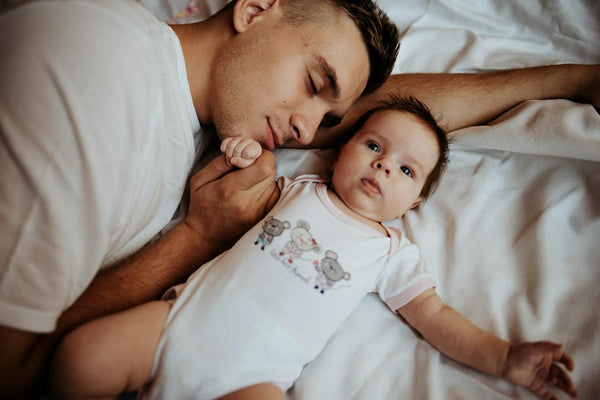 Dad lying in bed with baby
