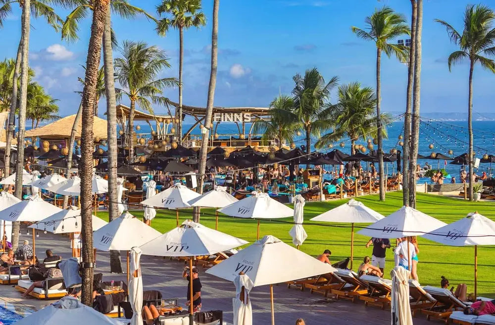 Finn's Beach Club in Canggu featuring the lawn and many lounges and umbrellas.