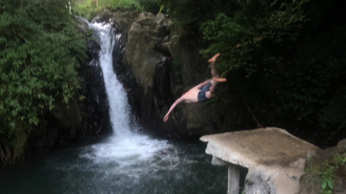 A guy diving into the Aling Aling waterfall in Bali.