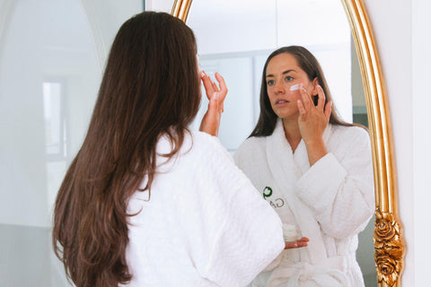 Woman in robe using GAIA spa products 