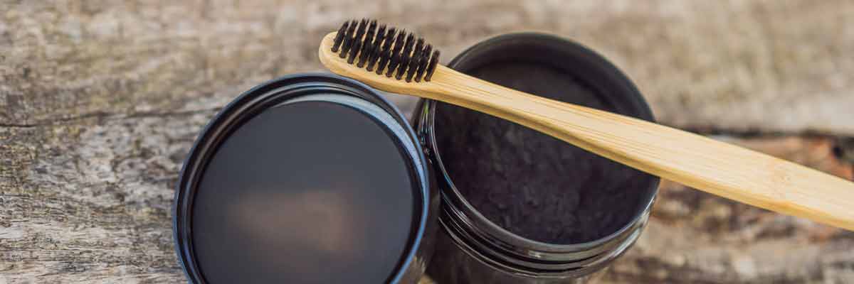 toothbrush on top of a container of charcoal toothpaste