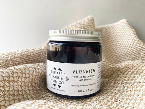 A jar of flourish hair butter in neutral background