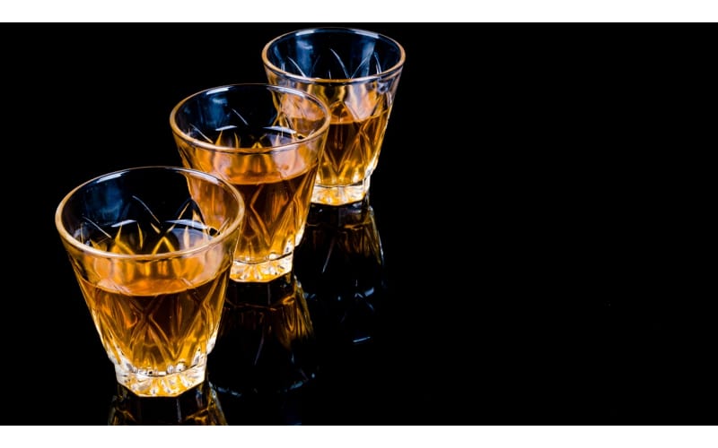 Tres vasos transparentes con whisky escocés