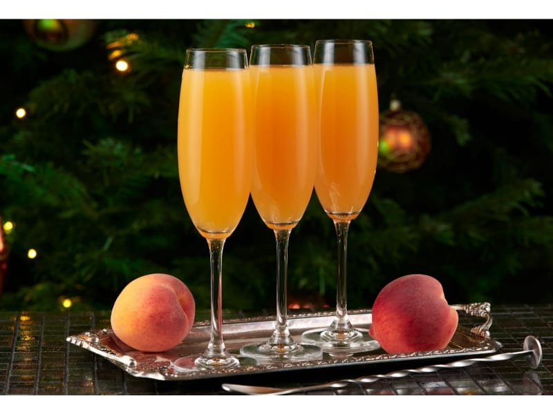 Three glasses of Baby Bellini with fresh peach fruits