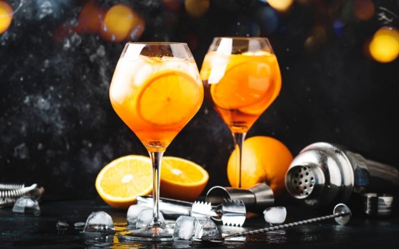 2 glasses of Aperol Spritz cocktails with bar tools