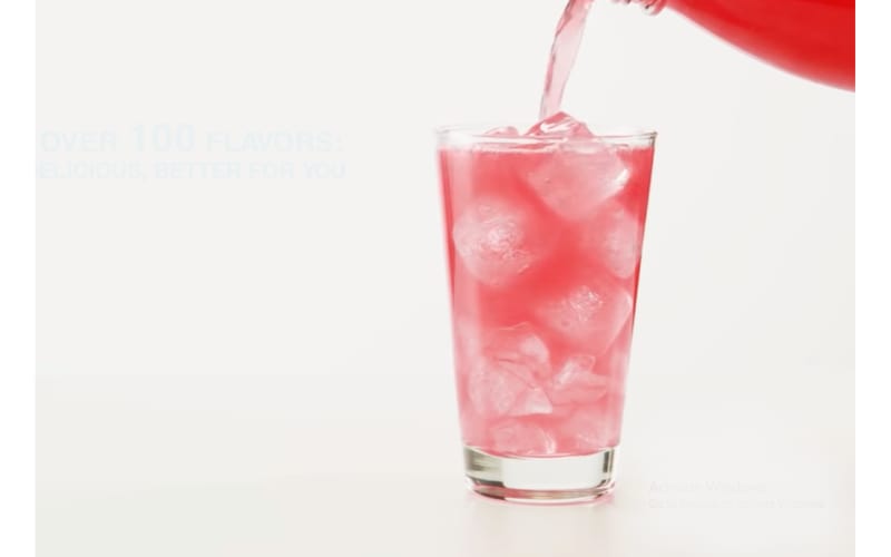 Red carbonated drink being poured into a glass