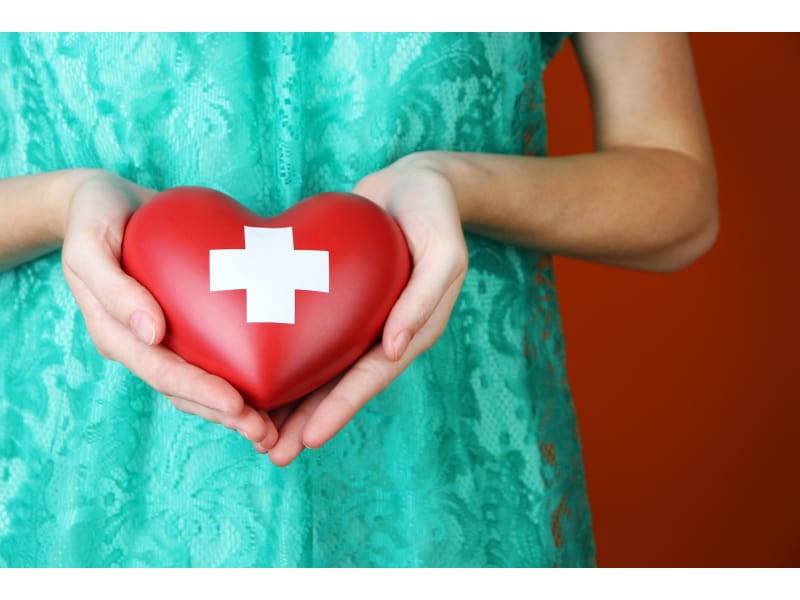 Woman holding a heart with cross